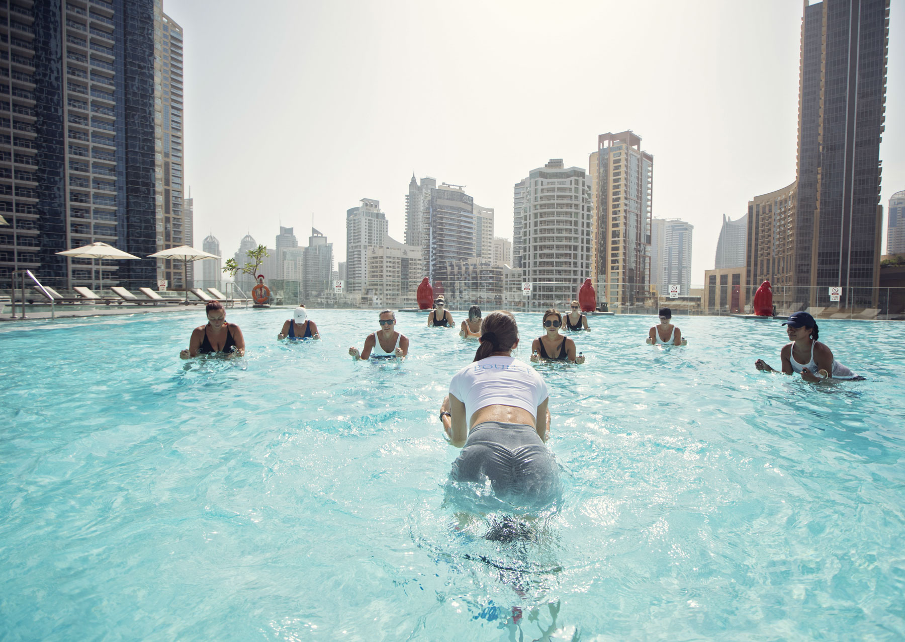 Aquafit aqua cycling class in a rooftop pool with the Dubai skyline